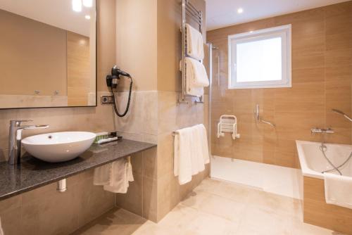 拉科鲁尼亚阿文尼达酒店的浴室配有盥洗盆、淋浴和盥洗盆。