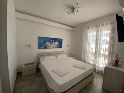 圣维托罗卡波Casa Diamante的白色的卧室设有床和窗户