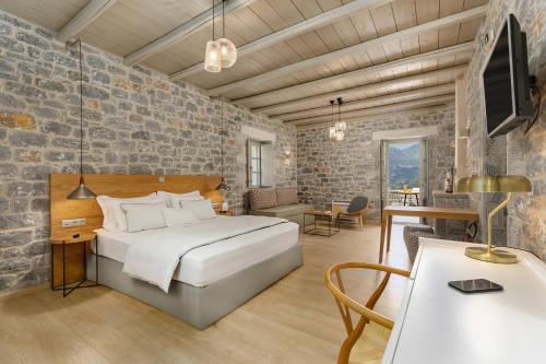利梅尼Trapela Limeni Luxury Suites的卧室配有一张床和一张桌子及椅子