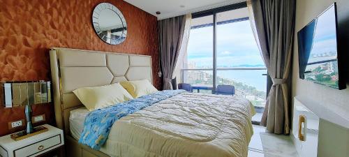 乔木提恩海滩Seaview Beachfront Skypool Rooftop Copacabana Jomtien Condo的一间卧室设有一张床和一个大窗户