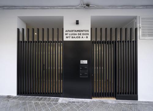 格拉纳达Apartamentos Mª Luisa de Dios Nº7的建筑物一侧有标志的黑色门