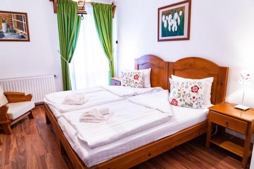 圣格奥尔基5.Evszak的卧室配有一张白色大床和木制床头板