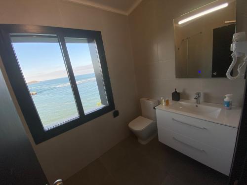 蒙达卡Mundaka Beachfront House的一间带水槽的浴室和一个海景窗户