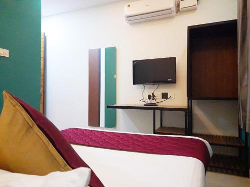 坦贾武尔Hotel Abedrooms- Budget stay Thanjavur的客房设有一张床、一张书桌和电视