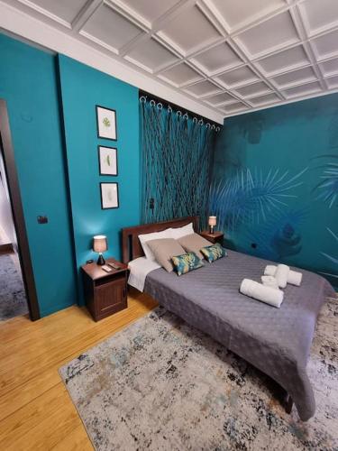 纳夫普利翁Deisisroomnafplio Zeus στ κέντρο του παλιο Ναύπλιο的一间卧室配有一张带蓝色墙壁的大床