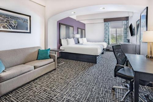 诺福克La Quinta Inn & Suites by Wyndham Norfolk的酒店客房,配有床和沙发
