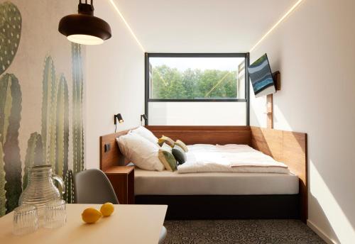 蒙塔鲍尔TIN INN Montabaur l einfach gut - Das Hotel aus hochwertig ausgebauten Überseecontainern的一间卧室设有一张床和一个窗口