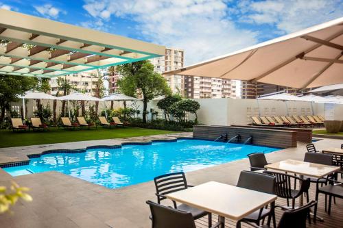 德班宜容格尼玛哈拉尼酒店的一张酒店游泳池的图片,里面摆放着桌椅