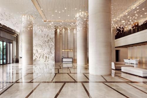 广州广州广交会威斯汀酒店的建筑的大厅,有柱子和吊灯