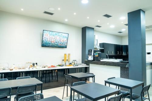 雅典New Amaryllis Hotel的一间带桌椅的餐厅和一间厨房