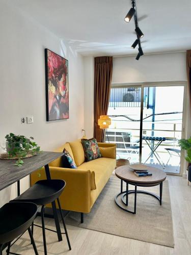 海法Haneemanim Apartments的客厅配有黄色的沙发和桌子