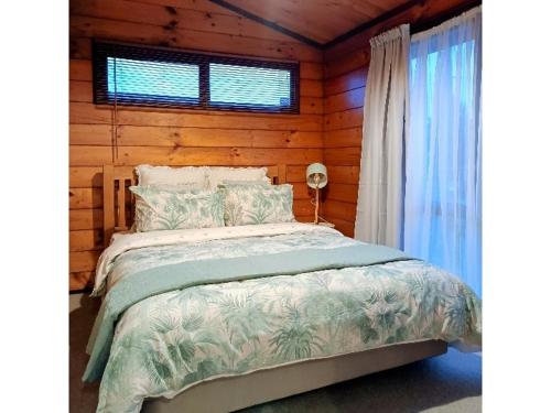 罗托鲁瓦Cosy in central Rotorua的小木屋内一间卧室,配有一张床