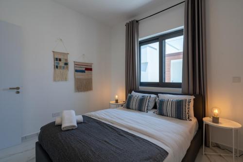 拉纳卡Yasou 1- Bedroom Apartment in Larnaca的一间卧室配有一张带两张桌子和一扇窗户的床。
