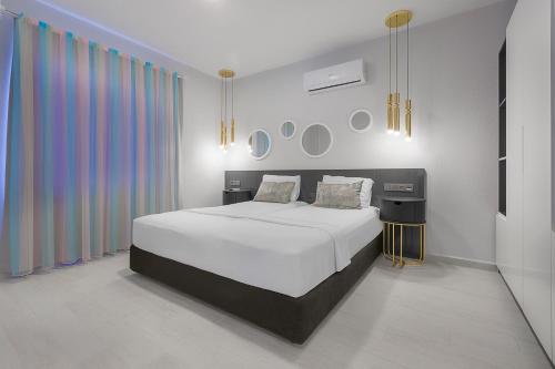 阿拉尼亚拜拉姆公寓酒店 的卧室配有白色的床和色彩缤纷的窗帘