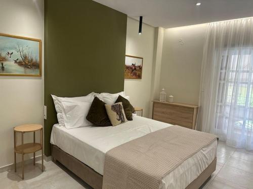 海若克利欧Eclectic Apartment near Downtown的一间卧室设有一张大床和绿色的墙壁