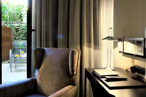 巴塞罗那Gran Hotel Havana 4Sup by Escampa Hotels的配有书桌和桌椅的房间