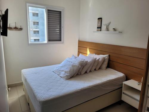 乌巴图巴Ubatuba - Praia das Toninhas的一间卧室配有带白色床单和枕头的床。