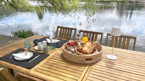吕斯坦Pieds dans l'eau Private Wellness Bordure de Meuse的餐桌上的野餐桌,上面有一篮子食物