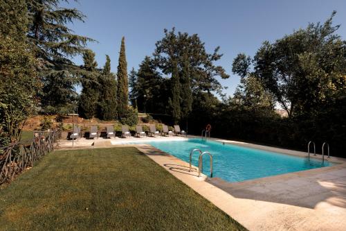 托雷洛多内斯托雷洛多内斯派克斯酒店的一座有树木和草地的庭院内的游泳池