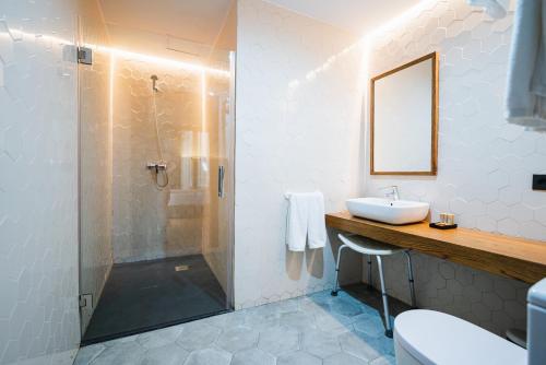 马拉加Málaga Premium Hotel的带淋浴、盥洗盆和镜子的浴室