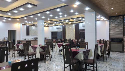 瓦迪穆萨Petra Guests Hotel的一间在房间内配有桌椅的餐厅