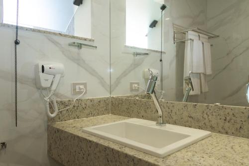 桑塔克鲁茨卡巴利亚Principe do Mutá Hotel Design的一间带水槽的浴室和台面上的电话
