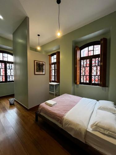 库里提巴Hostel Matilda的一间卧室设有一张大床和两个窗户。