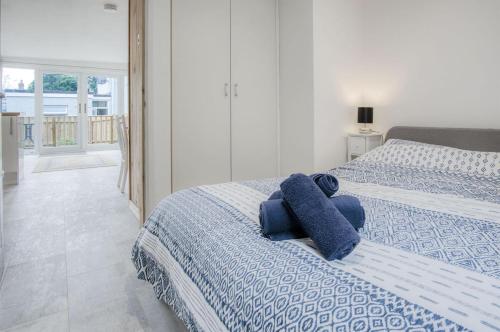 滕比The Garden Lodge - 1 Bedroom Lodge - Tenby的一间卧室配有两张床和蓝色毛巾
