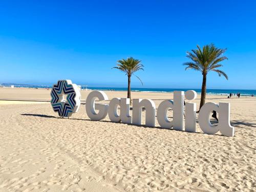 甘迪亚海滩Apartamento TalaMar Gandia Playa的两棵棕榈树海滩上的标志