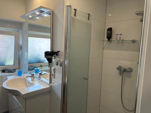 比斯平根Ferienwohnung Bispingen的带淋浴和盥洗盆的白色浴室
