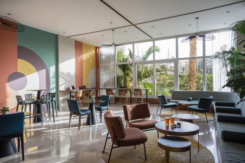 埃拉特埃拉特丹帕诺拉玛酒店的大堂设有桌椅和窗户。