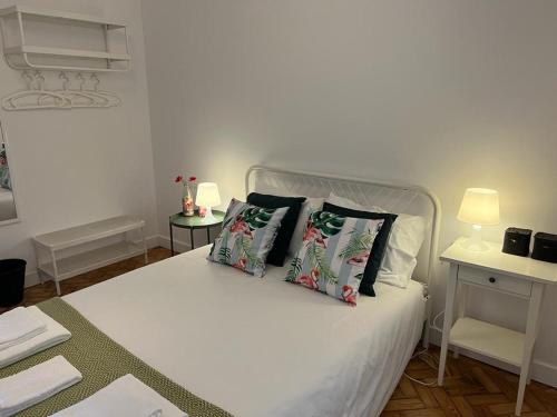 里斯本Alvalade II Airport Guest House的卧室配有白色的床和两个枕头