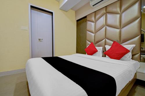 MadhyamgramHotel Snowfox的一间卧室配有一张带红色枕头的大床