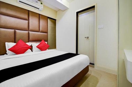 MadhyamgramHotel Snowfox的一间卧室配有一张带红色枕头的大床