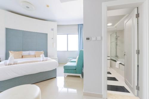 迪拜Downtown Luxury - 5 star Hotel Facilities - 5 min walk to Dubai Mall的一间卧室配有一张床和一张蓝色椅子