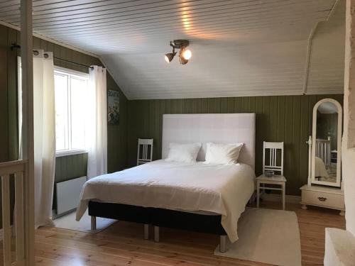 TöfsalaLittle Red School House的卧室配有白色大床和绿色墙壁