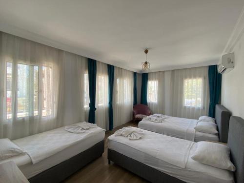 达特恰Gülhan City Otel的带窗户的客房内设有三张床。
