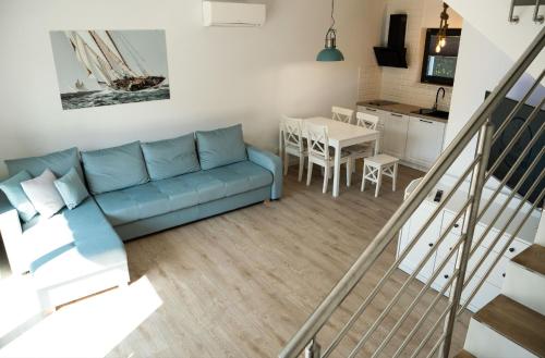 弗瓦迪斯瓦沃沃Domki Kapitalne的一间带蓝色沙发的客厅和一间厨房