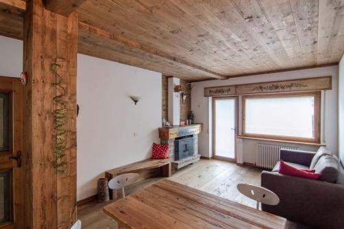 圣维托-迪卡多雷Estate in montagna的客厅设有木制天花板和桌子