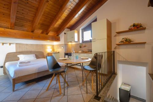 奥斯塔Inn Aosta Apartments的卧室配有一张床和一张桌子及椅子