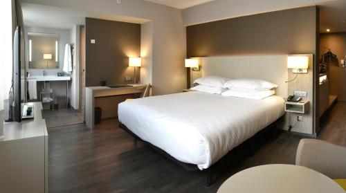 马赛AC Hotel by Marriott Marseille Prado Vélodrome的酒店客房设有一张白色大床和一个厨房