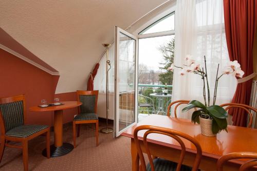 赫维兹Hotel Spa Hévíz的客房设有桌椅和窗户。