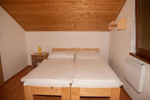 维尼Apartmány Alma的配有木天花板的客房内的两张床