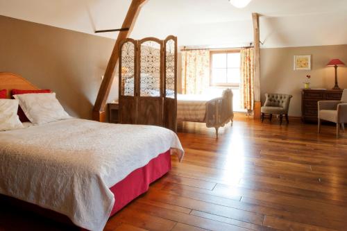 RoeulxFerme de l'Abbaye St-Feuillien的一间卧室配有一张床、一张桌子和一把椅子