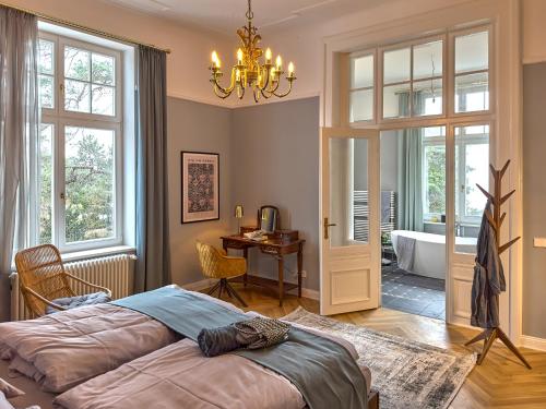 黑灵斯多夫Pineblue Villas的一间带一张床和一张书桌的卧室以及一间浴室。