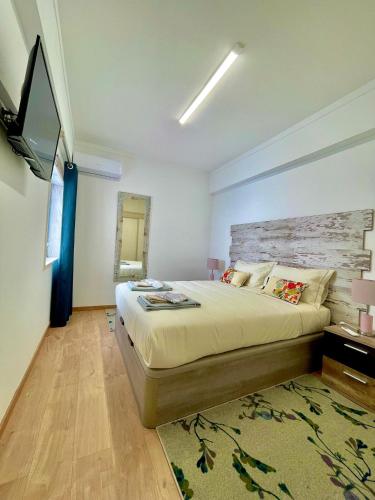 维拉维索萨APART Casas Brancas的一间卧室配有一张大床和电视
