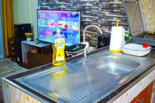 基苏木Casabella Apartment - Pristine Homes,Tom Mboya的带水槽的厨房台面和电视