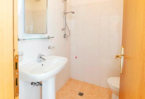 朱利亚诺瓦Hotel Holiday的白色的浴室设有水槽和卫生间。