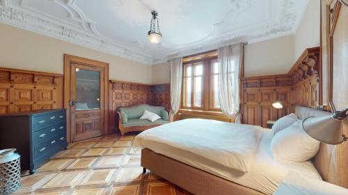 拉绍德封Architectural gem with vintage charm的一间卧室配有一张大床和一把椅子
