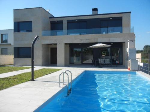 桑亨霍Chalet de diseño moderno en Sanxenxo的大楼前带游泳池的房子